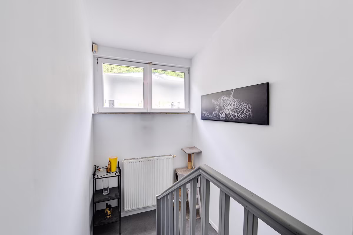 Cage d'escalier repeinte en blanc avec finitions soignées, peintre décorateur en région liégeoise